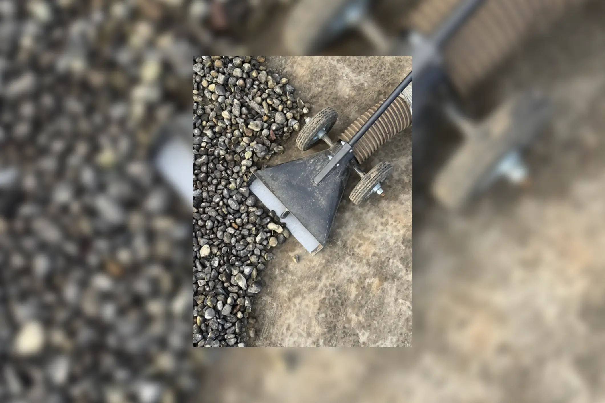 Wheeled vacuum head removing gravel from concrete